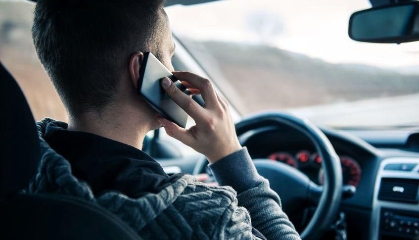 mężczyzna rozmawiajacy przez telefon w czasie jazdy samochdem