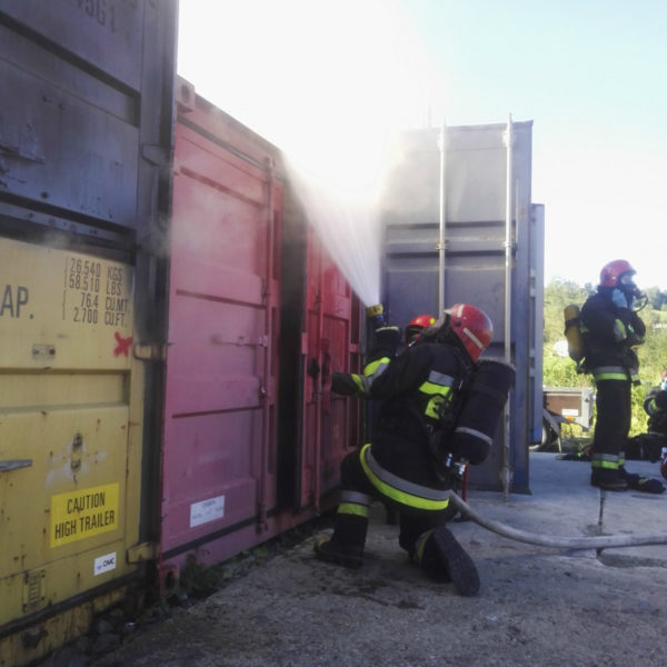 Zdjęcie ze szkolenia z zakresu gaszenia pożarów wewnętrznych - na zdjęciu strażacy gaszą ogień w magazynie