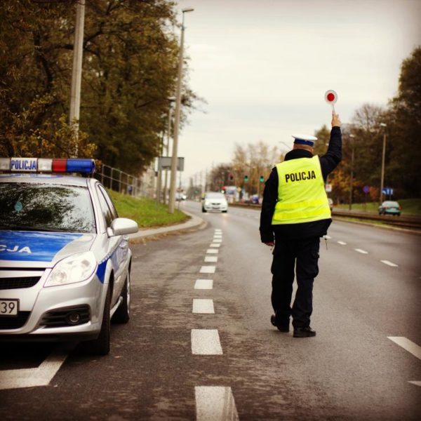 policjant w żółtej kamizelce podczas kontroli drogowej