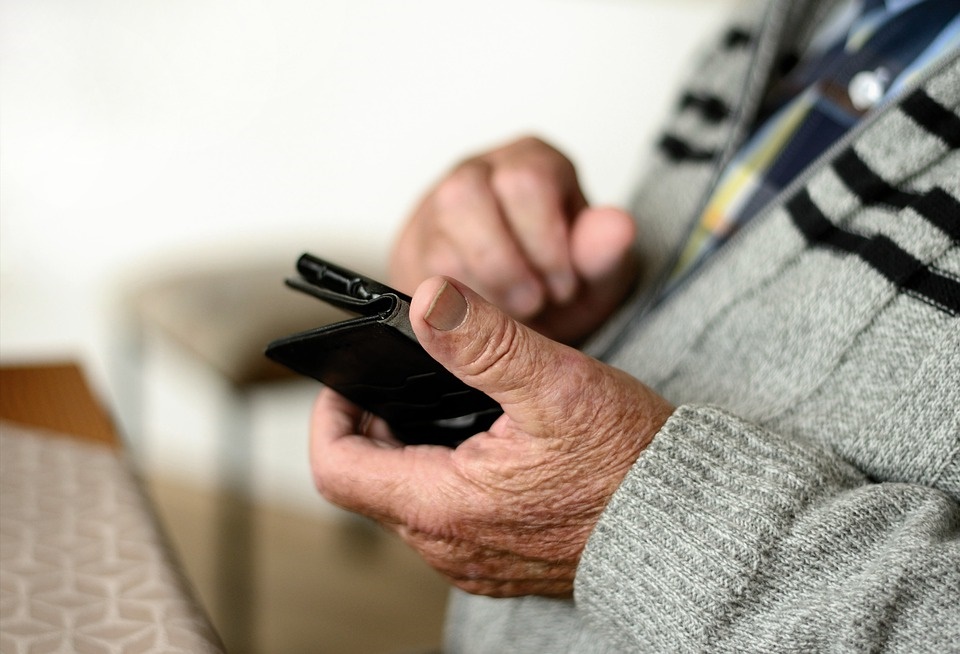 Małopolska infoliia dla seniorów- grafika przedstawiająca osobę starszą korzystającą z telefonu komórkowego