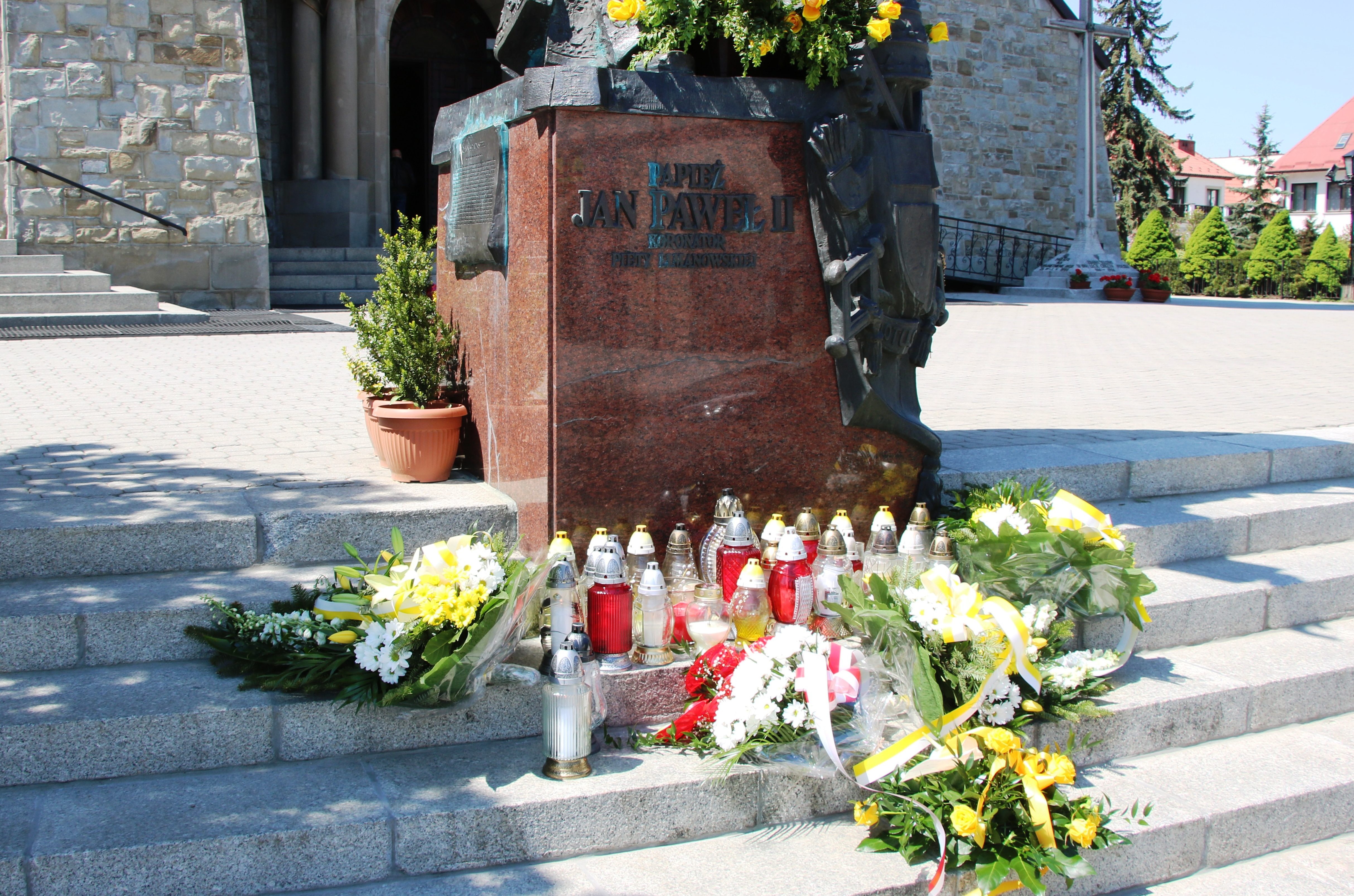 Obchody rocznicy 100. leci urodzin Karola Wojtyły- wiązanki i znicze przed pomnikiem Papieża Jana Pawła II przy Limanowskiej Bazylice