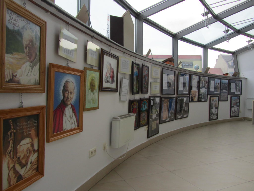 Zdjęcie przedstawiające wiszące obrazy na wystawie w Powiatowym Centrum Informacji Turystycznej 