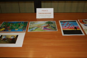 Zdjęcie pięciu prac nagrodzonych. Prace położone na stoliku. 