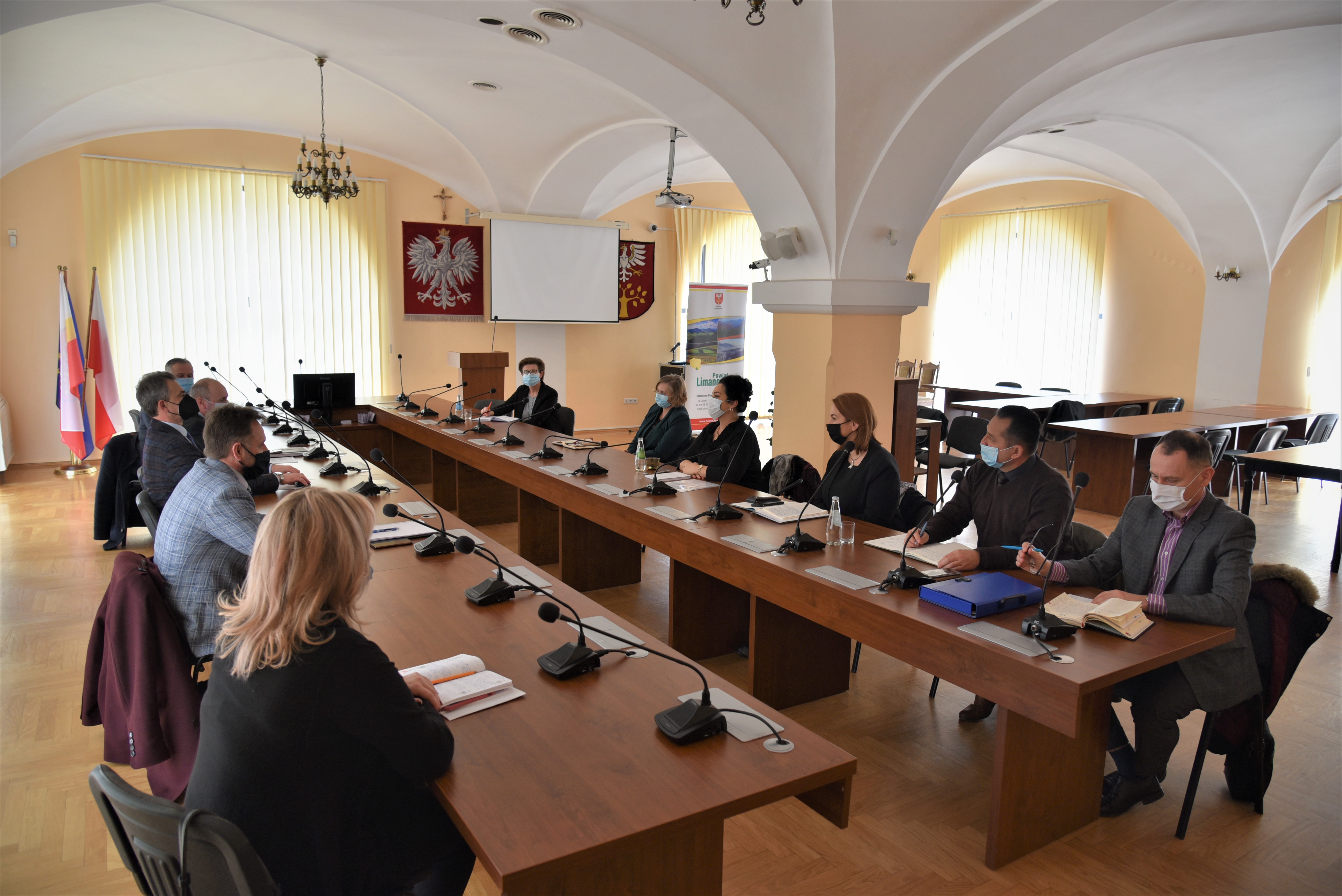 Dyrektorzy szkół siedzący naprzeciw siebie w sali konferencyjnej.