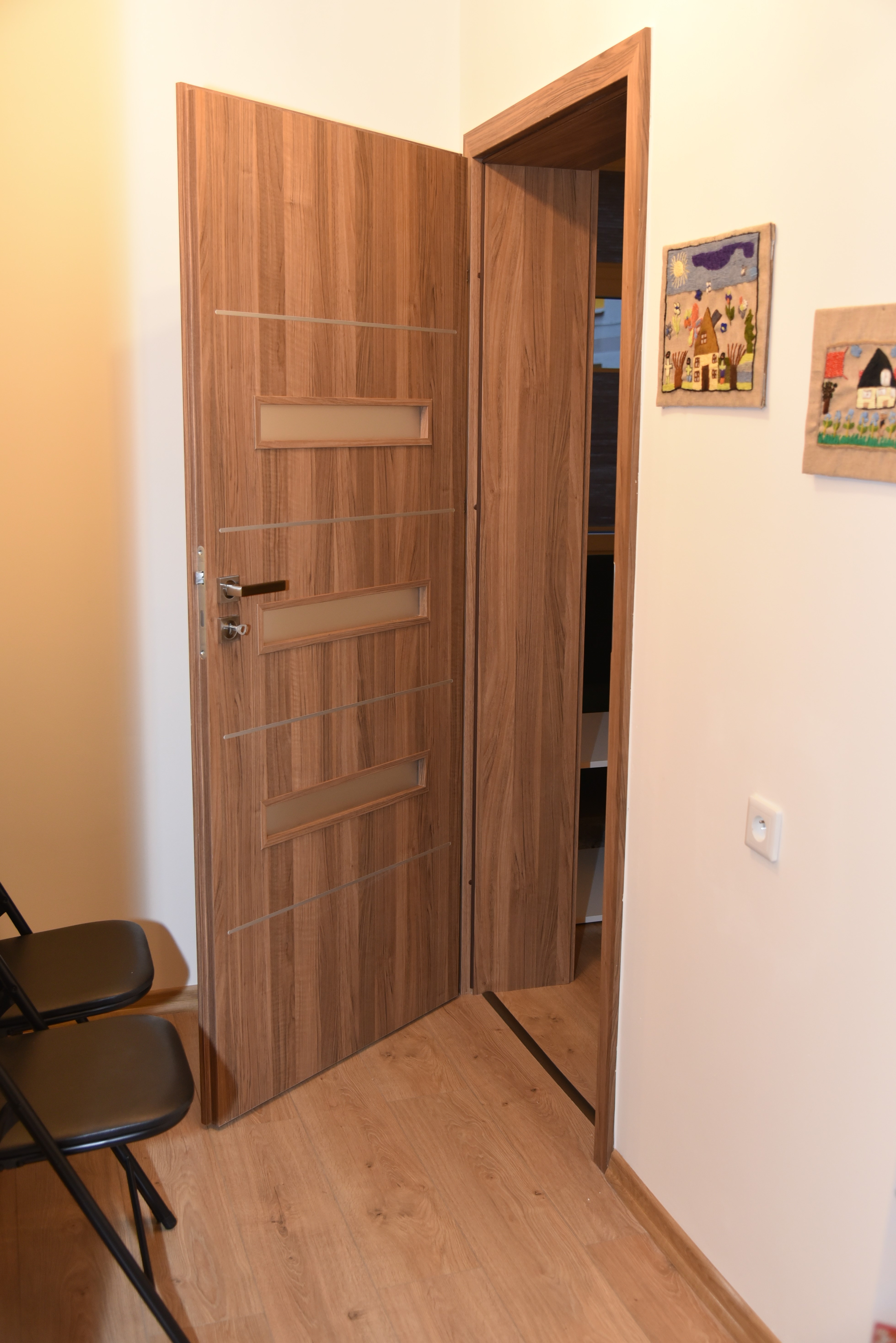 Zdjęcie przedstawiajace korytarz oraz otwarte drzwi priowadzace do jednego z pomieszczeń w nowym Ośrodku Interwencji Kryzysowej