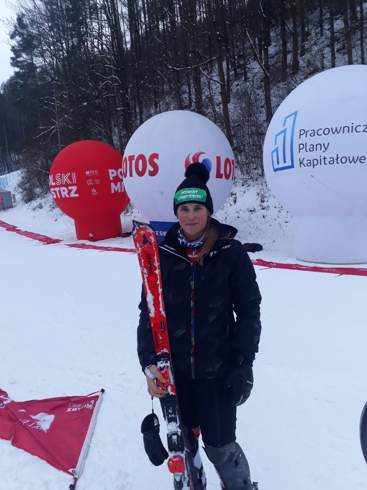 Patrycja Florek stoi z nartami na trasie zawodów.