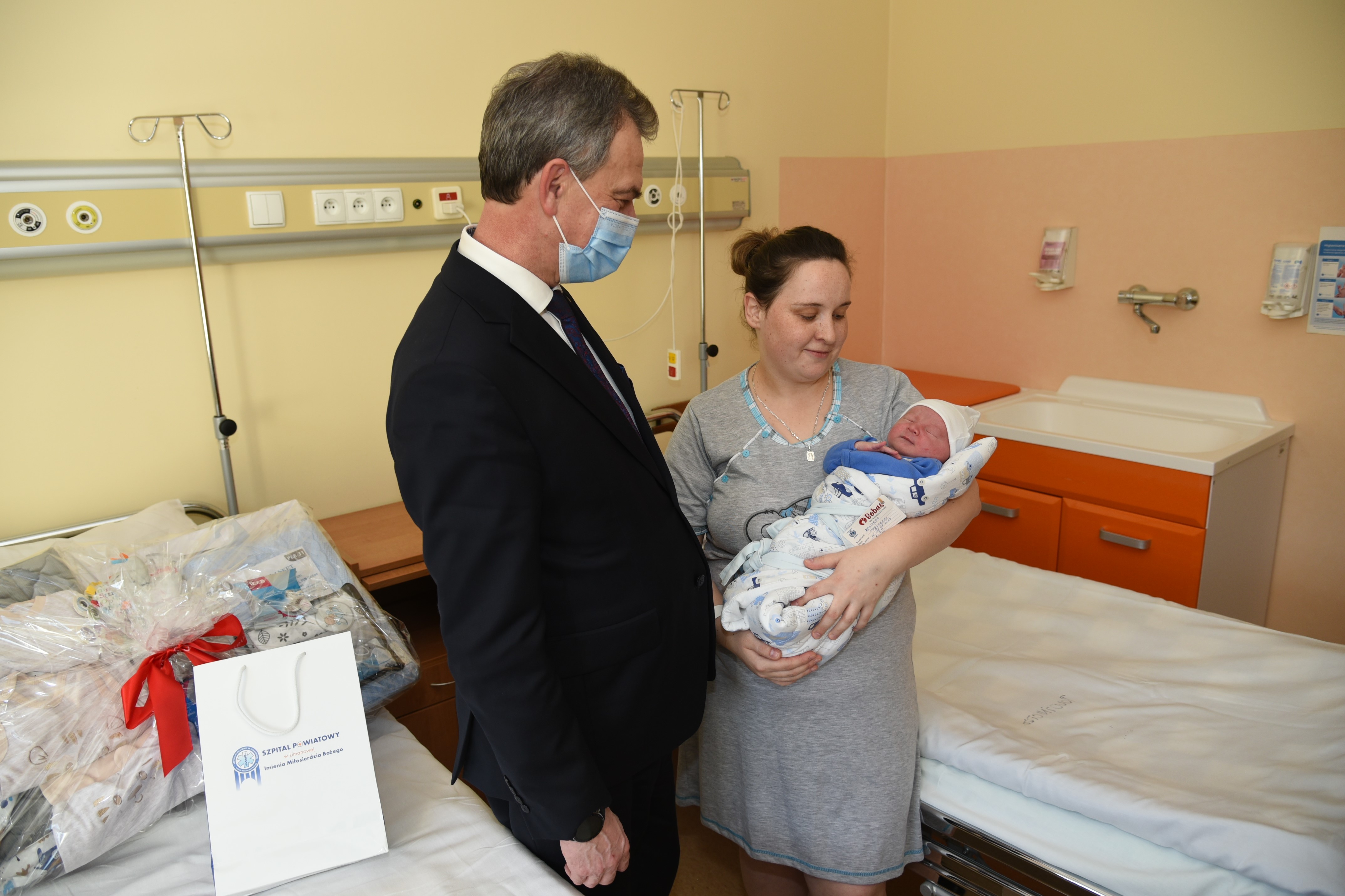 Starosta Limanowski wraz z pierwszym dzieckiem urodzonym w powiecie limanowskim w 2023 roku oraz mamą podczas odwiedzin w Szpitalu Powiatowym w Limanowej