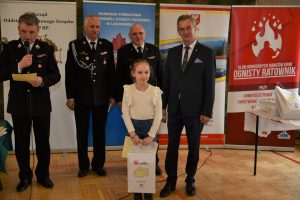 mała dziewczynka z nagrodą i w w towarzystwie starosty, przewodniczącego Pietrzaka i komendanta straży