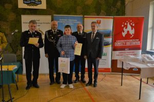 zaycięzca Hubert Bugajski z nagrodą i w towarzystwie starosty, przewodniczącego Pietrzaka i komendanta straży