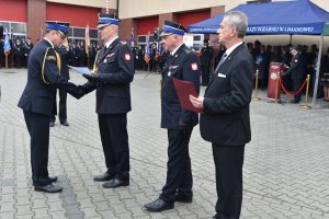 komendant wręcza awans strażakowi oficerowi, obok stoi starosta Uryga