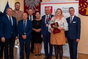 Małgorzata Gal z listem gratulacyjnym i różą w towarzystwie starosty i radnych zagórzańskich