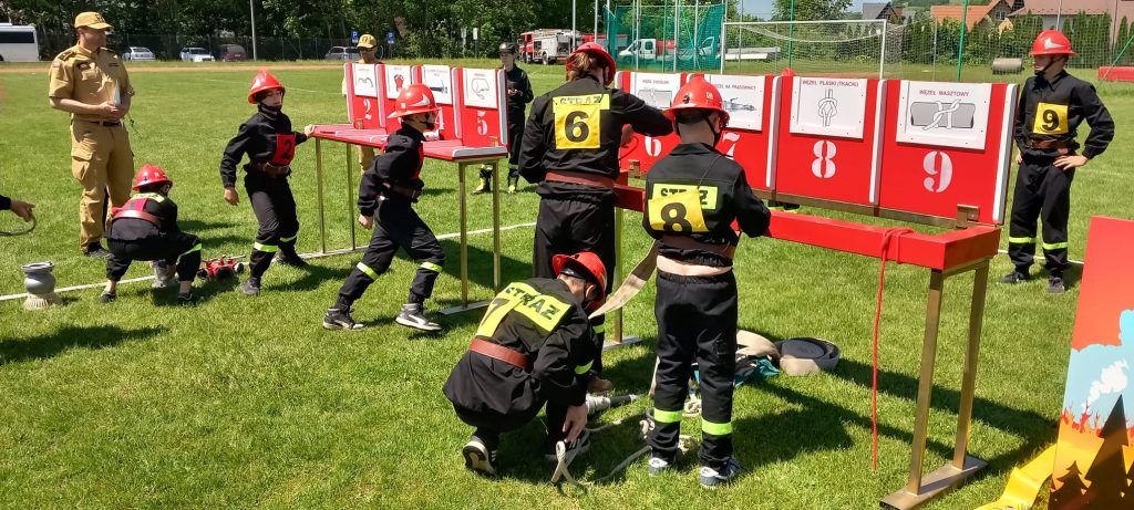 czterech strażaków przy tablicach konkursowych