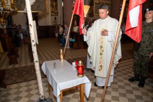 kapłan dokonuje poświęcenia urny z prochami