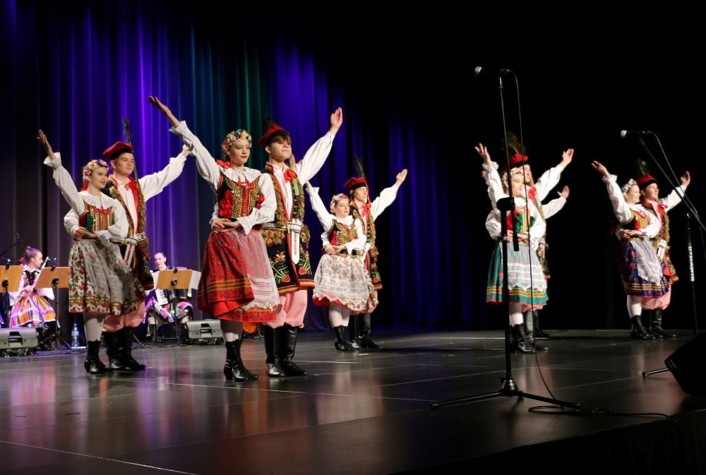 tancerze w krakowskich strojach na scenie podczas występu
