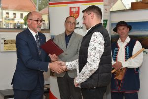 Wojciech Włodarczyk wręcza list gratulacyjny Karolowi Wojtasowi