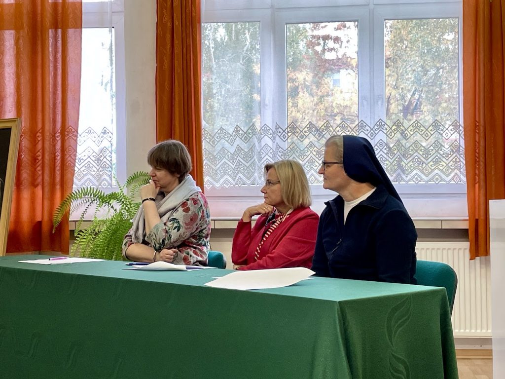 trzy kobiety z komisji siedzą przy zielonym stole