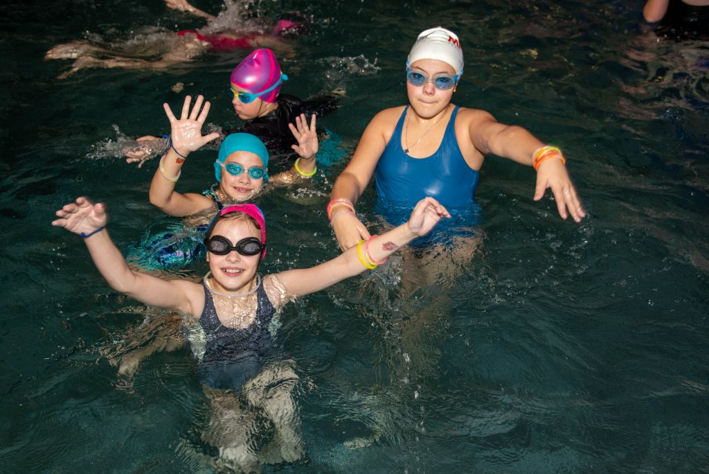 cztery dziewczynki w basenie zwrócone w stronę aparatu