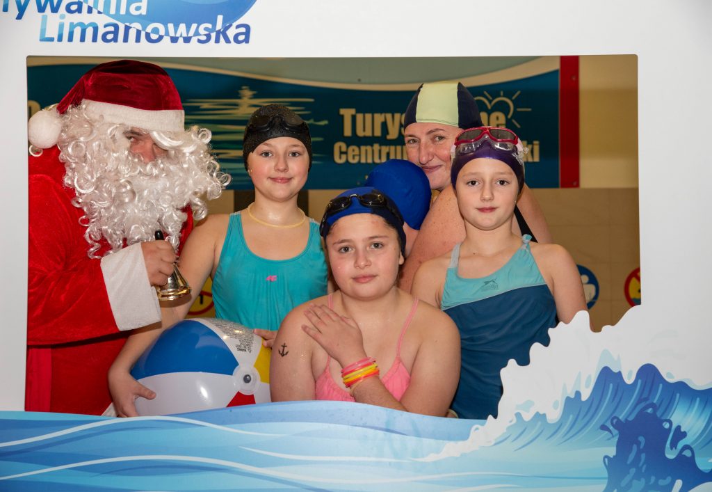 Mikołaj i dwojMikołaj i dzieci z mamą w ramce zdjęciowej Pływalni
