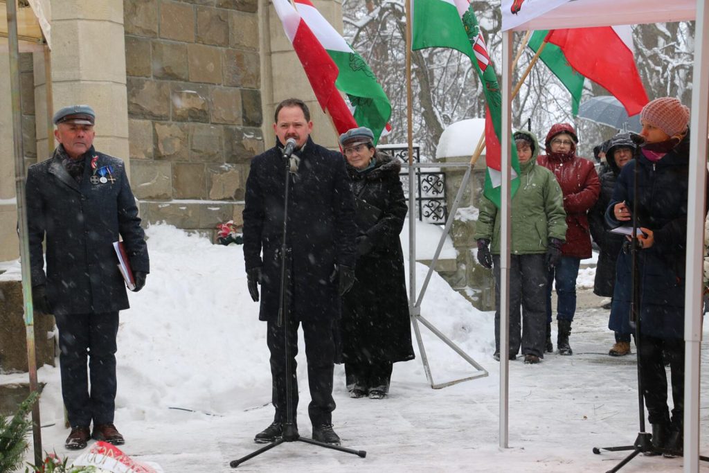 osoby na tle flagi węgierskiej