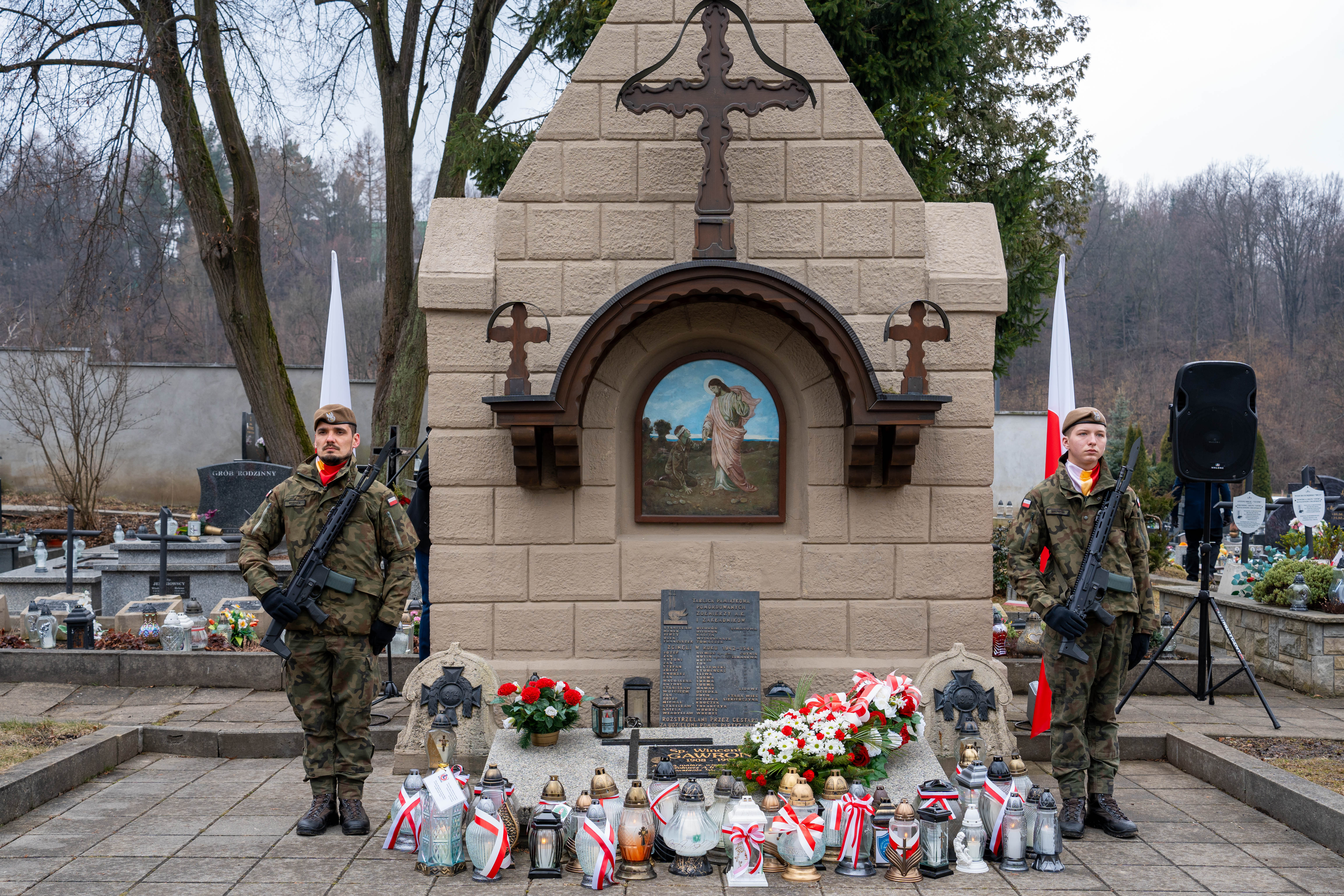 Dwóch żołn ierzy przy pomniku pamięci Żołnierzy Wyklętych