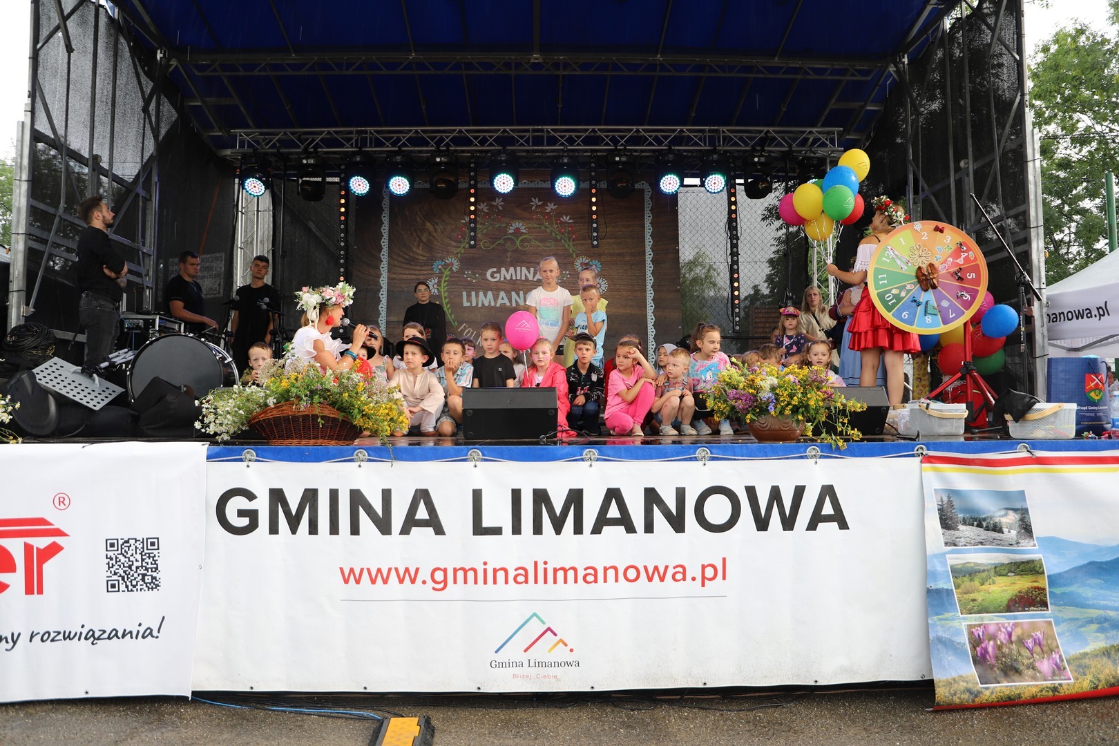 Grupka dzieci siedzi na scenie